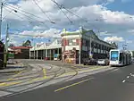 A photo of Kew tram depot. There is one C-class stabled and another C-class is passing the depot on Barkers Road.