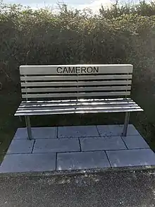 A metal bench with the name "Cameron" cut through the back.