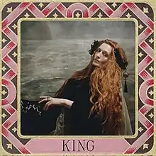 A picture of Florence Welch sitting sideways while gazing into the camera. The picture is surrounded by a medieval-styled border with the text "King" written below.