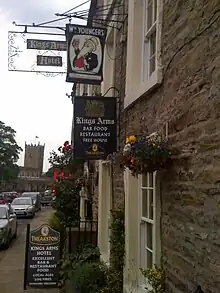 The pub's main entrance in 2011, including a sign for W. M. Youngers Brewery. St Oswald's Church is in the background