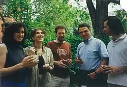 Five happy-looking people at a lawn party.