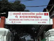 Signboard of Kathmandu Metropolitan City Office in Ranjana script (second row).