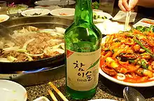 Green bottle on a table with food