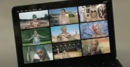 A still of the music video for Gwen Stefani's 2020 single "Let Me Reintroduce Myself", displaying a laptop broadcasting a Zoom call with nine different versions of the singer.