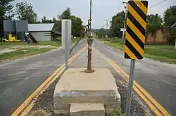 A 1904 community hand pump surviving modern encroachment in 2010 on the middle of Main Street at La Russell, Missouri, USA.