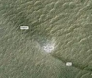 Dust Devil, as shown from HiRISE.  Dust devil is moving to the upper left, leaving a dark track to the lower right.  The shadow of the dust devil is to the upper left of the dust devil.