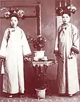 Two ladies of Qing Chinese Imperial Court wearing longhua with Qizhuang, pre-1911.