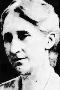 An older white woman, in a high-contrast black-and-white newspaper photo