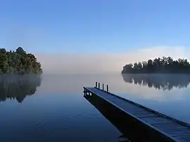 Image 17Lake MapourikaPhoto credit: Richard PalmerMorning mist on Lake Mapourika, a lake on the West Coast of New Zealand's South Island. It is the largest of the west coast lakes, a glacier formation from the last ice age. It is filled with fresh rain water which runs through the surrounding forest floor, collecting tannins and giving it its dark colour.