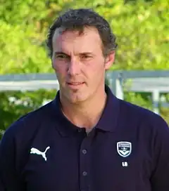 A middle aged man, wearing a dark blue top