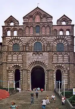 The facade of Notre Dame du Puy, in the southwestern Auvergne region, is built of brick, local white sandstone and black volcanic stone (11th century)