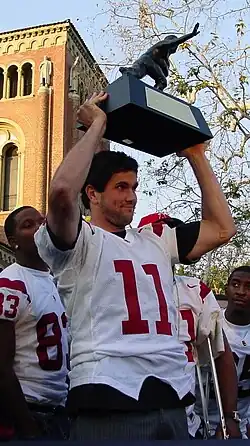 =Matt Leinart holding a championship trophy above his head in 2005