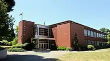 A side view of Lincoln High School—a brick, two-story building with an American flag