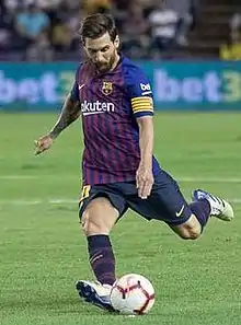 A man, wearing a blue and red football shirt.