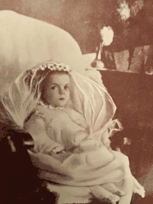 a child wearing a white first communion dress