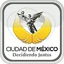 Logo of a black-and-white sculpture, El Ángel. It is a victory symbol personified by an upper naked angel wearing a long skirt. She holds a laurel wreath with her right hand. Below her image, two golden wings are displayed. The slogan "Ciudad de México" is written in black capital letters, with the word "México" bolded, and below the slogan "Decidiendo Juntos" with the same pattern. The whole image is located inside a gray squircle.