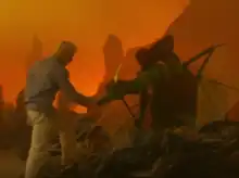 A shot of Nottet touching the jaws of a faux dragon, against an orange backdrop.