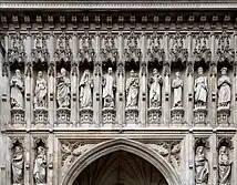 Statues of ten people in niches over a door