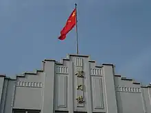 Picture of Longmen Building and Chinese Flag.