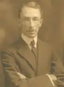 A sepia photo of a man in a suit with a tie.