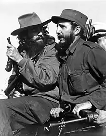 Fidel Castro gives a speech, while Camilo Cienfuegos watches from his side