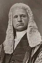 Man in long wig and black and gold legal robes