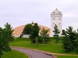 Photograph of a golden dome and a white tower.