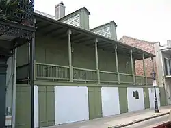 A photograph of the facade of a green house.