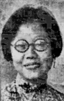 A young smiling Asian woman, wearing round glasses. Her dark hair is cut to jaw length.