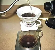 Image 53In a pour-over, the water passes through the coffee grounds, gaining soluble compounds to form coffee. Insoluble compounds remain within the coffee filter. (from Coffee preparation)