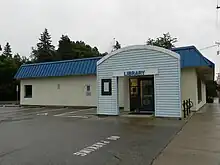 Maple Plain Library, a one-story white building with a blue sloped roof and a teal, arched entryway.