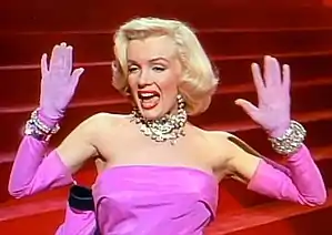  Woman in hot pink dress dancing and singing with both arms raised