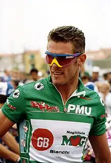 A cyclist wearing a green jersey.