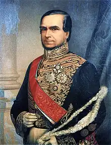 Official half-length portrait of the Marquis, who is seated with official hat in hand and wearing white gloves and a gold embroidered tunic with medals of various orders, over which is worn a red sash of office.