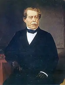 Painted three-quarters length portrait of a seated man with gray mustache who is wearing a black frock coat, white shirt with wingtip collar and black cravat, and black gloves