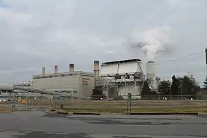 A steam station with a large cooling tower expelling a cloud of vapor