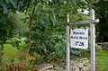 A sign marking the location of the Martin House and Farm, with the farmhouse seen through the trees