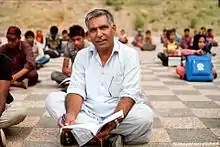 Ayub sitting among his students at a park in Islamabad in 2016