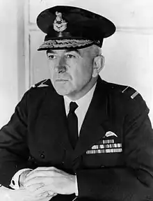 Half portrait of man in dark military uniform with peaked cap