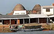 Brickmaking kilns, Mekong Delta. The cargo boat in the foreground is carrying the rice chaff used as fuel for the firing.