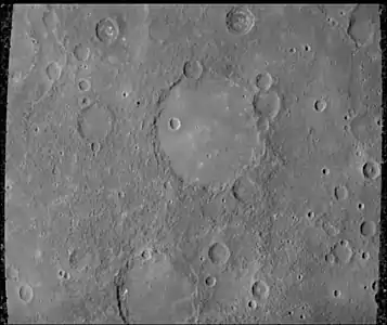 The Schubert basin, 190 km (120 mi) in diameter, filled by smooth plains. The basin's hummocky rim is partly degraded and cratered by later events.