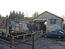 Stone building with steam railway engine outside it.