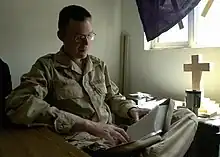 A U.S. Navy chaplain in Iraq studies his Bible for an upcoming service.