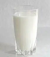 A red-capped bottle of milk with cream along the top.