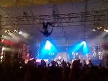 Kody Nielson hangs upside down over the stage during a performance at Auckland University of Technology