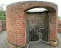 The chimney on top of the furnace. The new outer wall has a gap for viewing the original inner wall (badly damaged by overheating) and down into the furnace