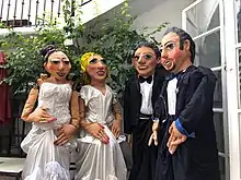 Four mojigangas-- giant puppets made from paper mâché and fabric--dressed in wedding clothing