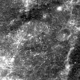 Molière crater at a high sun angle.  The crater is barely distinguishable due to high sun angle and lack of shadows. The southern rim is in the lower left corner.