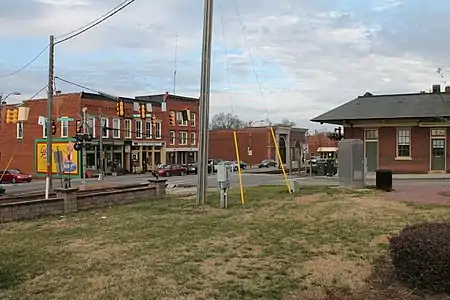 A present-day view down a busy street lined with buildings from 1890 to 1960; A view of Broad Street, part of the Historic District