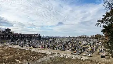 Panoramic view of the old section of the Monumental Cemetery of Mortara standing at the edge of the right central porches and the city of Mortara on the horizon (from north-east to south-west)